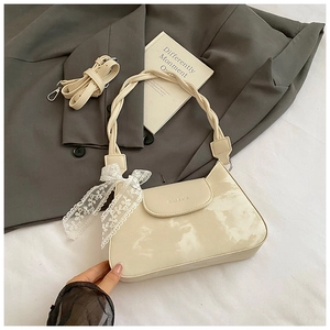 Detail of off-white baguette bag with cloud dye pattern, lace bow and braided strap