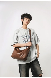 Close-up of minimalist brown leather crescent crossbody bag with large capacity for men