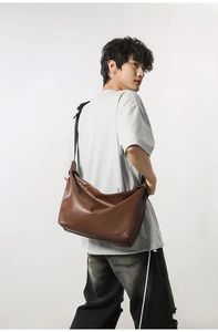 Detail view of large brown PU leather messenger bag with adjustable shoulder strap