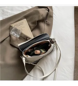 Detailed interior of a beige flap bag showing storage space for phone and makeup
