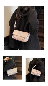 Detail view of light pink baguette bag with silver chain and glossy faux leather texture