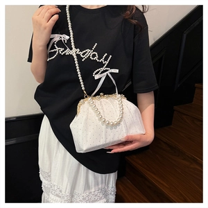 Detail of vintage white mesh evening bag with pearl embellishments and gold metal clasp