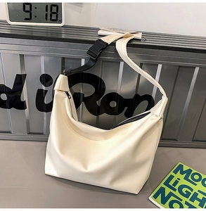 Detail view of cream white large tote bag featuring black zipper and adjustable strap buckle