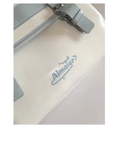 Détails de la broderie Aimaier et des coutures sur un sac cabas en cuir crème