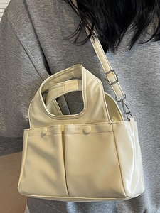 Minimalist beige faux leather tote bag with flap pockets and adjustable crossbody strap