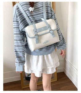 Vue détaillée du sac à dos style JK en similicuir crème avec bretelles bleu clair sur modèle