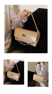 Detail showing glossy pleated patent leather texture and silver chain strap on chic bag