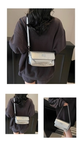 Detailed macro view of silver metallic bag featuring a chic chain and leather shoulder strap
