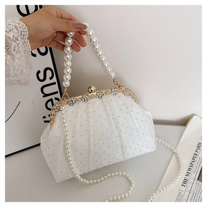 Detail of white pleated evening bag with rhinestone clasp and pearl beaded handles