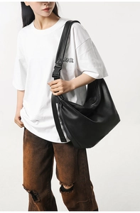 Detailed view of black large capacity tote bag with adjustable tactical buckle strap on model