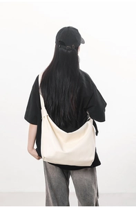Detail view of large minimalist cream tote bag shown on model for high street commute style