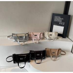 Collection of stylish baguette bags in various colors on a white minimalist display stand