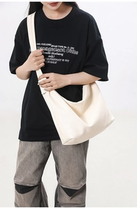 Detail of minimalist cream large tote bag with wide strap on model in studio