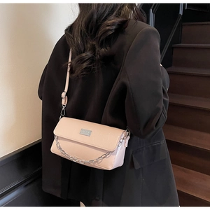 Detailed view of nude pink baguette bag with silver chain and adjustable shoulder strap