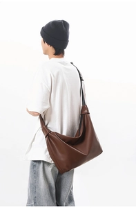 Brown leather large tote bag with adjustable black shoulder strap in back view model shot