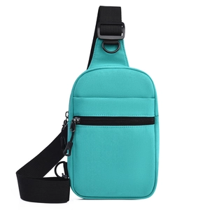 Détail du sac de poitrine en toile vert menthe avec compartiments zippés et bandoulière