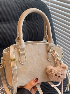 Cream crocodile texture bucket bag with gold hardware and a cute plush bear charm