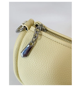 Close-up of litchi texture leather bucket bag with silver metal zipper detail