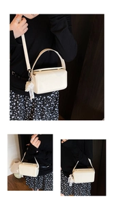 Détail d'un sac à main boîte blanc crème avec dentelle et perles sur une tenue noire