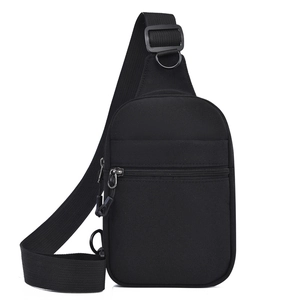 Détail du sac de poitrine en toile noire montrant la fermeture éclair et la bandoulière