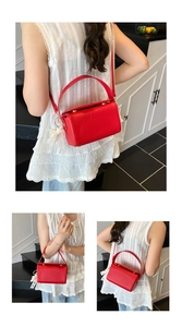 Détail du sac boîte en cuir rouge avec nœud en dentelle et perle sur le côté