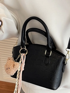 Fashionable black crocodile embossed bucket bag with plush bear charm and gold hardware