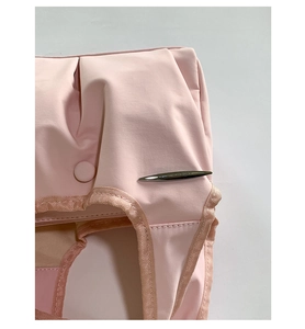 Detailed close-up of pink pleated tote bag with sleek silver spindle metal accent