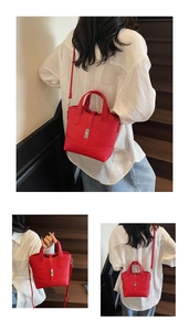Detail of red pebbled leather tote bag with silver buckle and adjustable shoulder strap