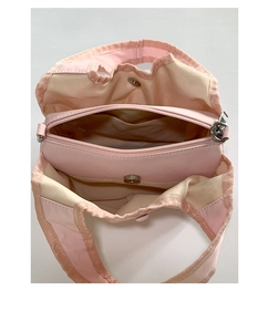 Detail view of pink nylon tote with multiple compartments and silver magnetic snaps