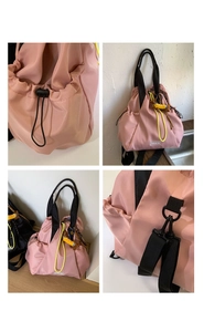 Detail of light pink nylon backpack featuring yellow drawstrings and fashion woven label