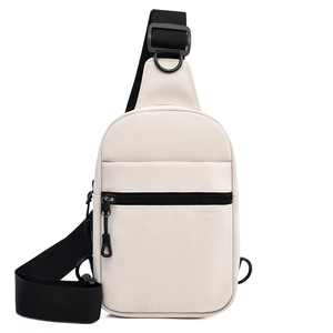 Détail du sac de poitrine en toile beige avec bandoulière réglable en nylon noir et anneaux en D