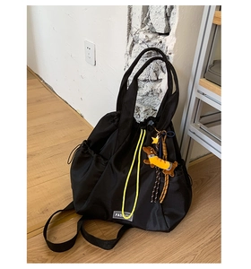 Detail of nylon drawstring backpack with fashion label and yellow star dog charm accessory