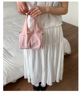 Detail view of pink nylon tote bag with silver D-ring and elegant magnetic closure