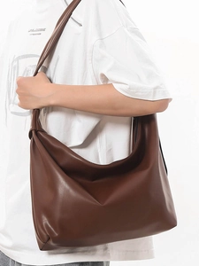 Minimalist brown half-moon tote bag for women shown as a stylish large shoulder bag