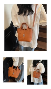 Detail of caramel brown pebble leather tote bag featuring dual handles and silver turn-lock
