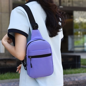 Détail d'un sac de poitrine en nylon violet avec bandoulière noire réglable et compartiments