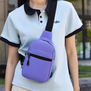 Détail du sac de poitrine en toile violette avec fermetures noires et sangle réglable