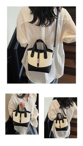 Detailed view of the contrast color canvas tote with silver metal buckle and adjustable strap