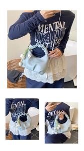 Détail d'un sac à main bleu clair avec poignée plissée et charm floral tulipe blanche