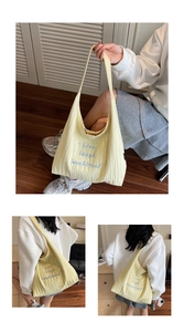 Dettaglio della borsa tote in lino giallo chiaro con ricamo blu 'Live laugh love'