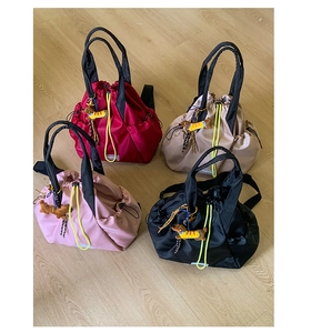 Nylon drawstring backpacks in red, khaki, pink, and black with dachshund charms