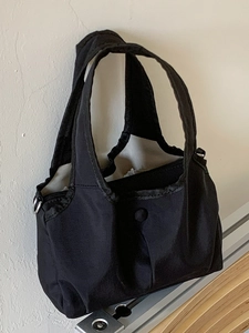 Minimalist black nylon shoulder bag with durable handles and metal rings for daily fashion