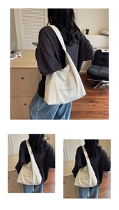 Dettaglio della borsa tote bianco sporco con ricamo blu e trama a pieghe alla moda