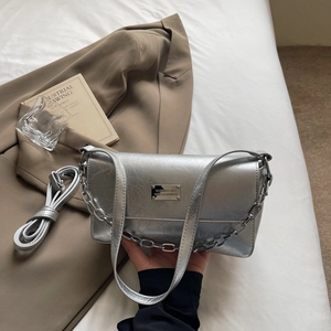 Detailed shot of silver metallic baguette bag with wrinkled texture and chain strap