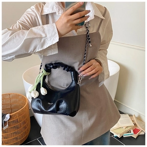 Détail du sac hobo noir avec logo argenté et pendentif de tulipe blanche décoratif