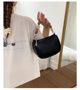 Detail of black lychee grain leather bucket bag with marble bead handle and metal zipper