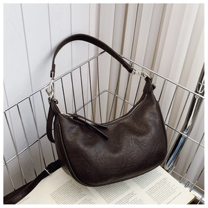 Detail of dark brown vintage hobo bag with logo embossing and silver metal zipper accent