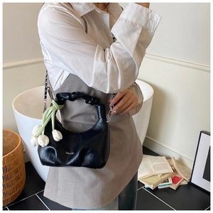 Détail du sac hobo croissant noir avec breloques tulipes blanches et chaîne argent