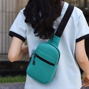 Détail du sac de poitrine en toile vert menthe montrant la poche et la bandoulière