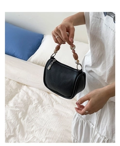 Close-up of black lychee leather bucket bag with marble textured beads handle
